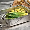 Edelstahl-Bräter mit gegrilltem Spargel und Kartoffeln auf Marmor-Arbeitsfläche
