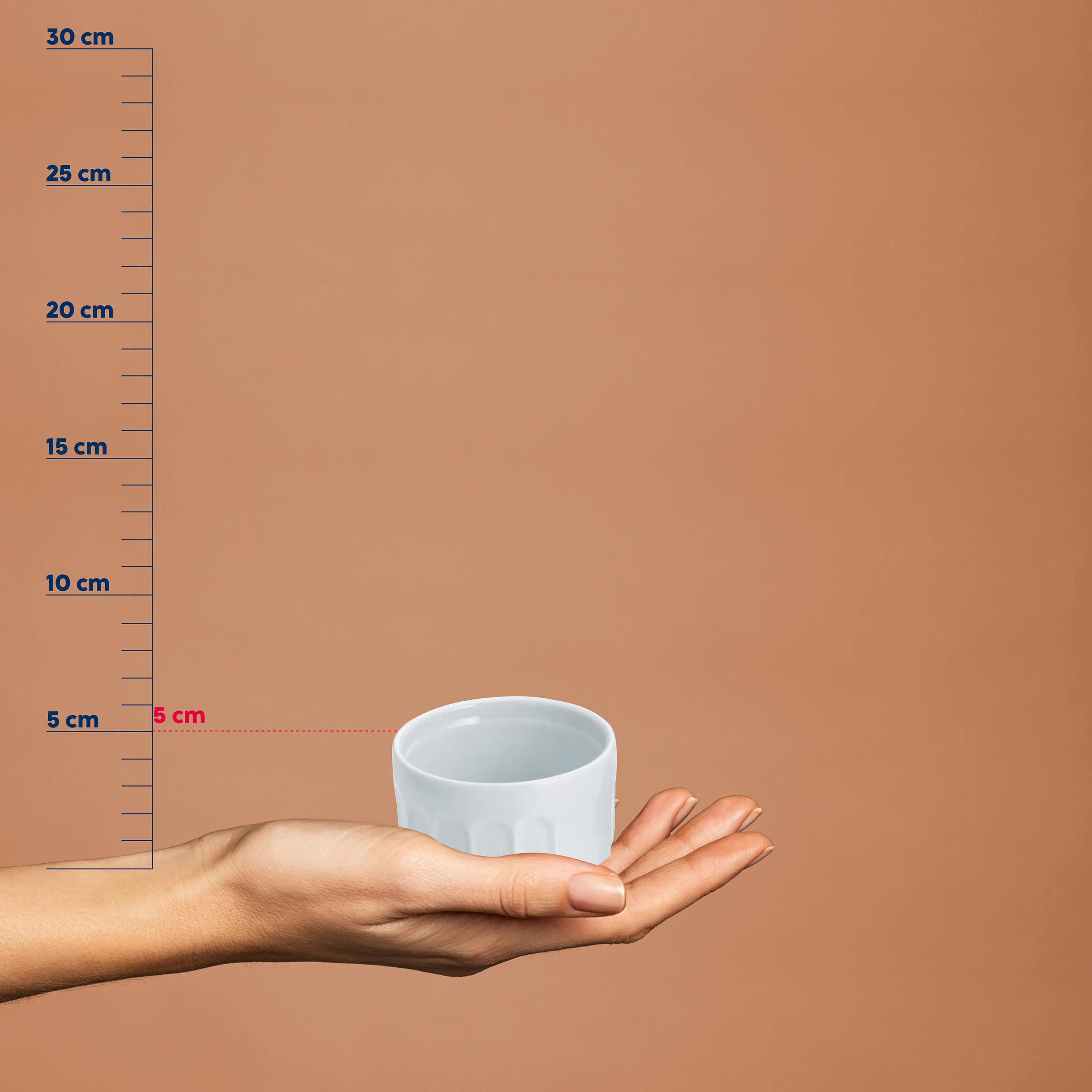 Kleine Keramikschale Größenvergleich mit Maßstab Weiße Keramikschale in einer Hand vor Maßstab, zeigt Größe von etwa 5 cm Höhe