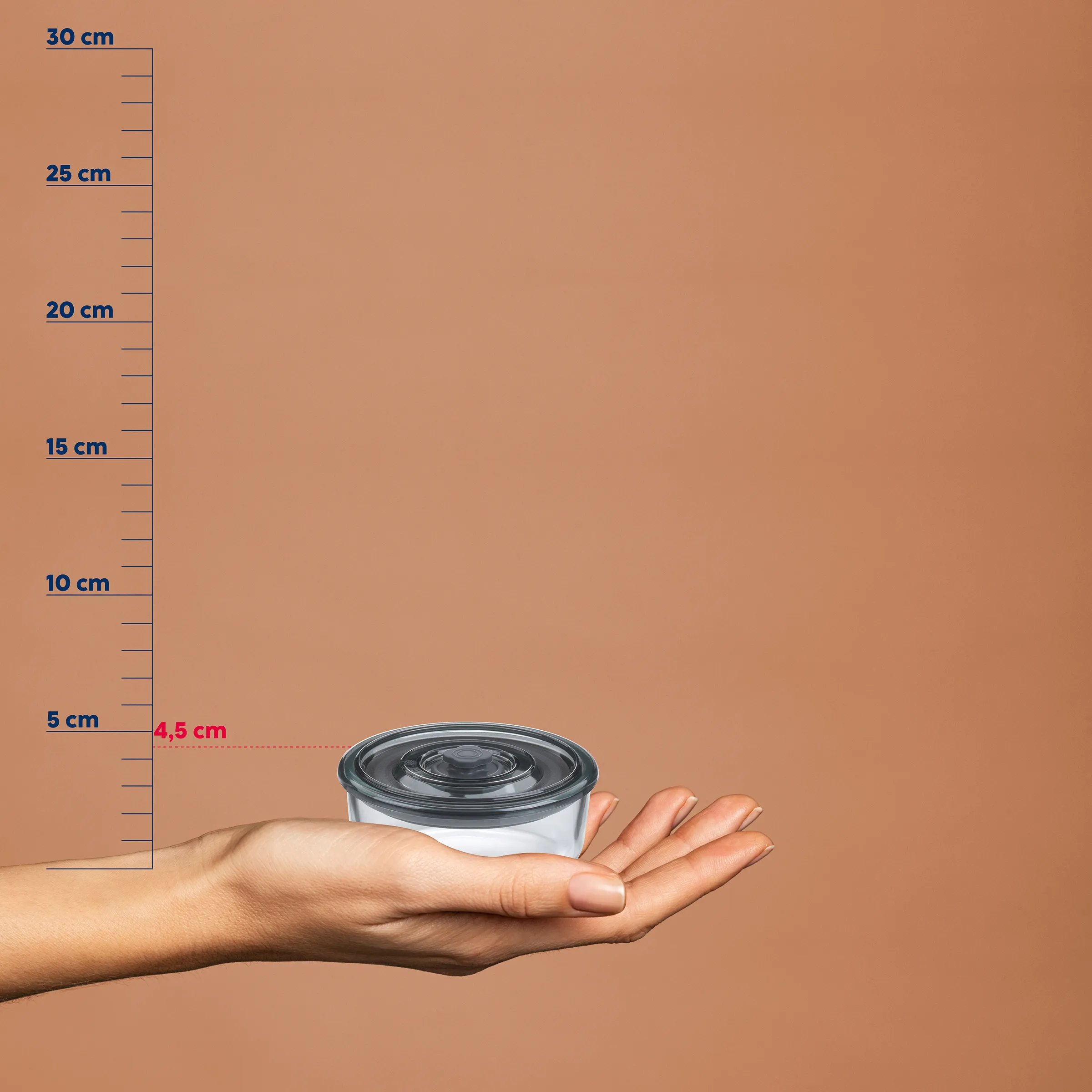 Kleine Aufbewahrungsdose Kunststoff 4,5 cm Höhe Hand hält kleine runde Kunststoffdose mit schwarzem Deckel vor Messskala, Höhe 4,5 cm