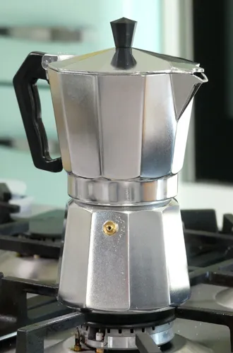 Espressokanne Aluminium auf Gasherd - Italienische Kaffeezubereitung Silberne Espressokanne auf Gasherd in moderner Küche