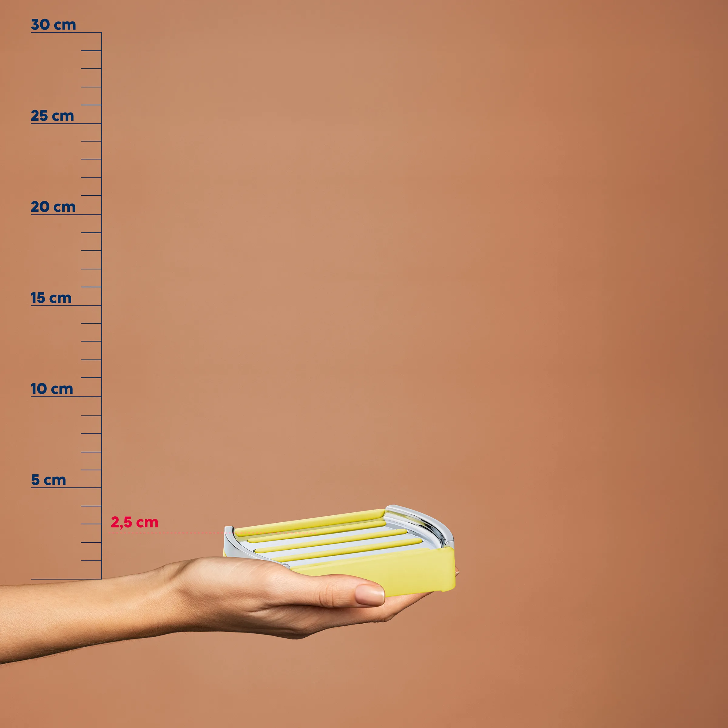 Hand hält gelbes Schnur-Haarband mit 2,5 cm Höhe vor Maßstab