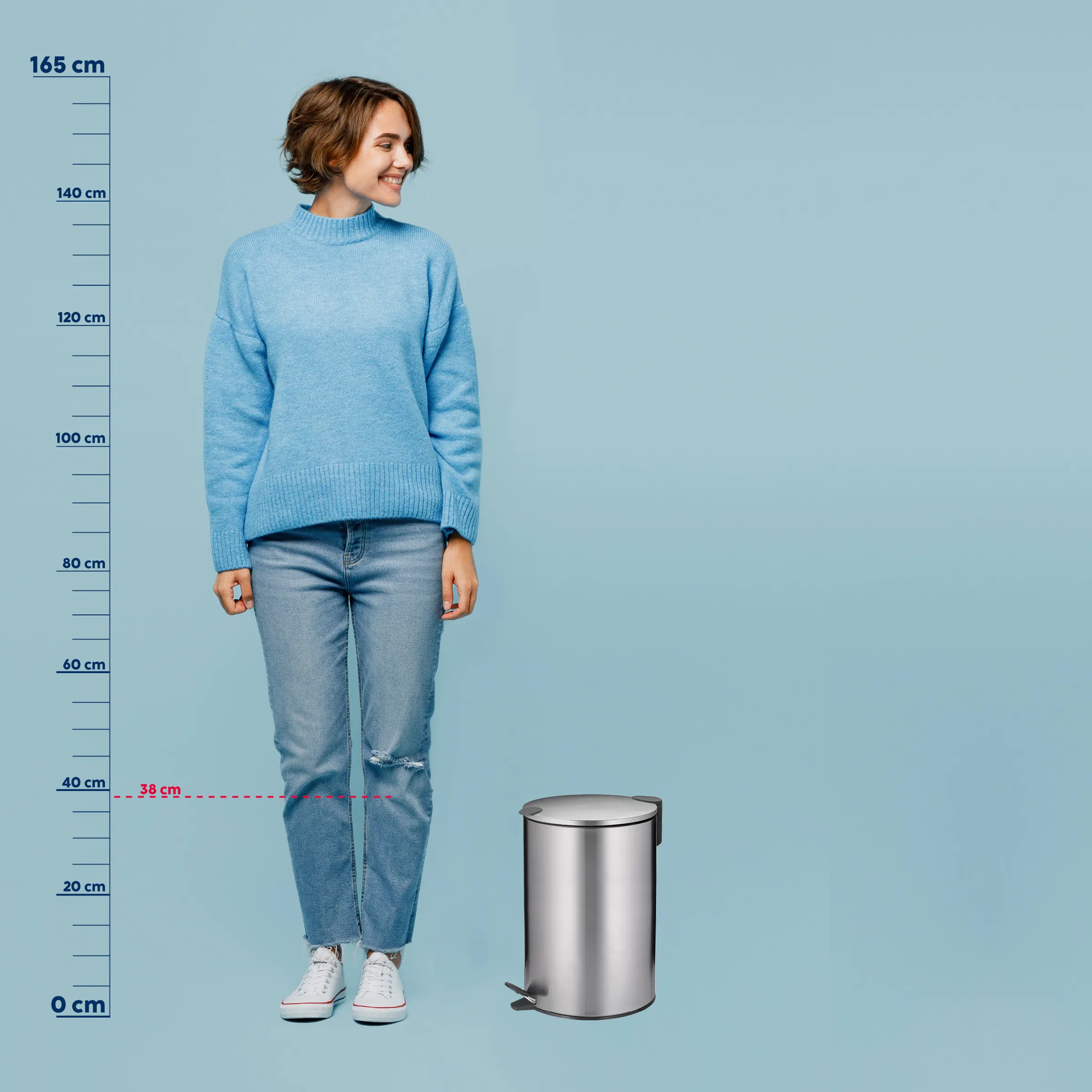Tretmülleimer silber 38 cm - Abfalleimer mit Größenvergleich Silberner Tretmülleimer 38 cm Höhe neben einer Person als Größenvergleich vor blauem Hintergrund