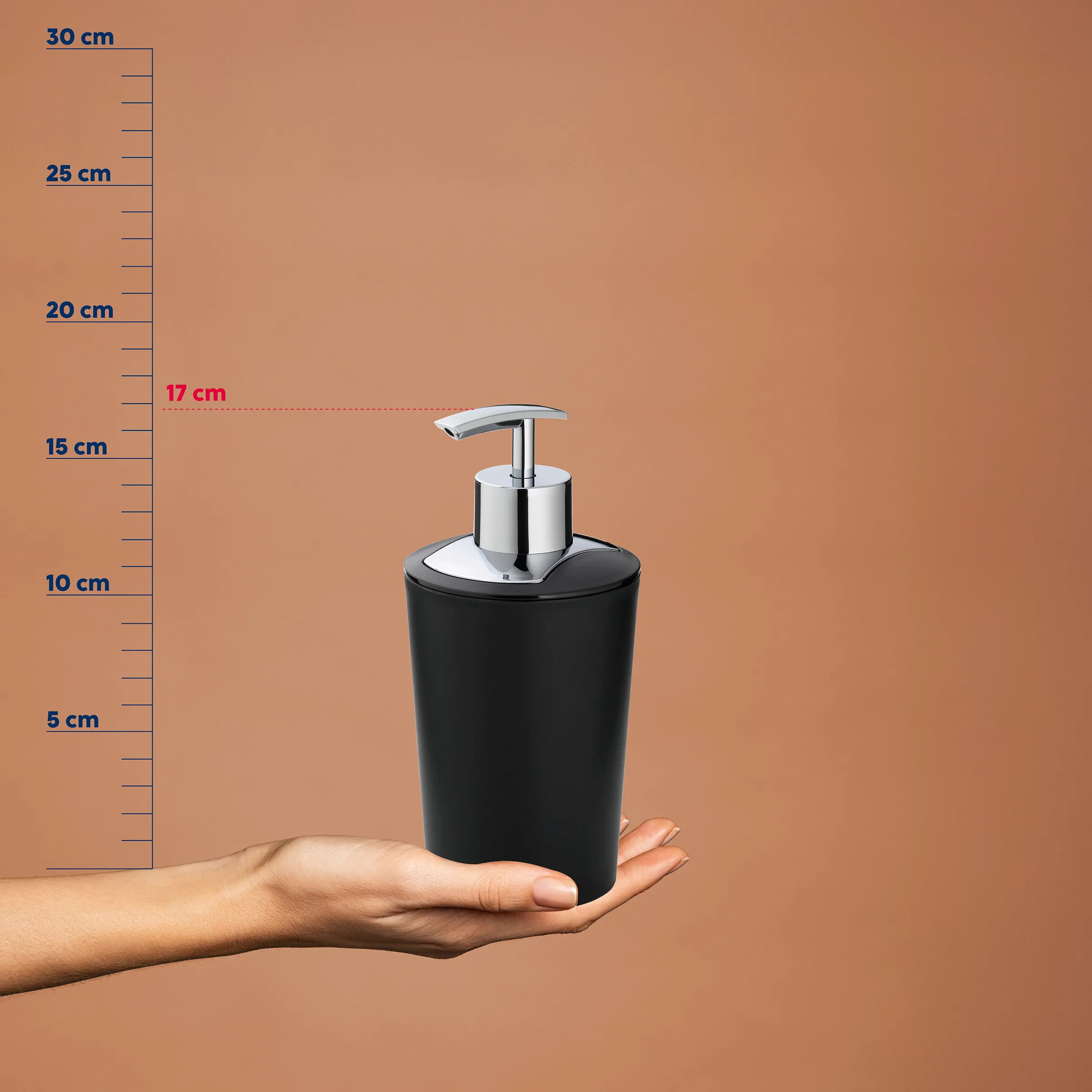 Schwarzer Seifenspender mit Chrompumpe - 17 cm Höhe Badezimmer Dispenser Schwarzer Seifenspender mit Chrompumpe, 17 cm hoch, auf Hand vor Messskala auf beigem Hintergrund