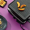 Reise-Kosmetiktasche schwarz mit Schmuckzubehör und Aufbewahrung Schwarze strukturierte Reise-Kosmetiktasche mit goldenem Schmuck und Münzen auf violettem Hintergrund