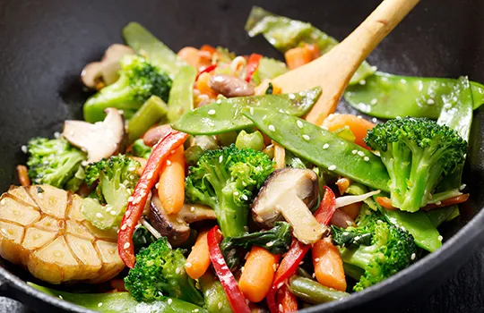Gemüse Stir Fry Rezept mit Brokkoli und Tofu Gemüsepfanne mit Brokkoli, Paprika, Pilzen und Tofu in Wok mit Holzlöffel