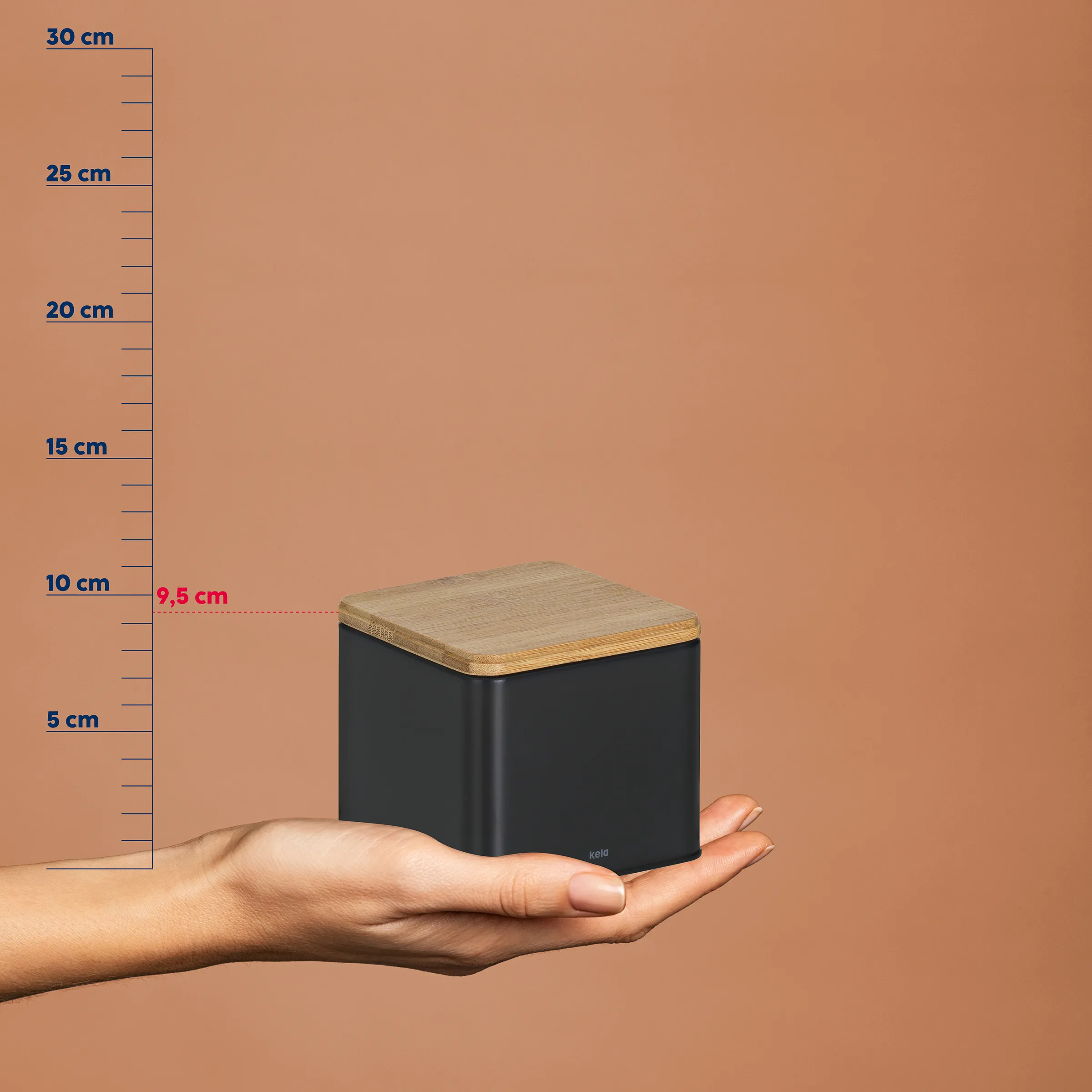 Aufbewahrungsbox Holz klein - Kompakte Aufbewahrung mit Deckel Schwarze Aufbewahrungsbox mit Holzdeckel in einer Hand, Größenvergleich zeigt etwa 9,5 cm Höhe