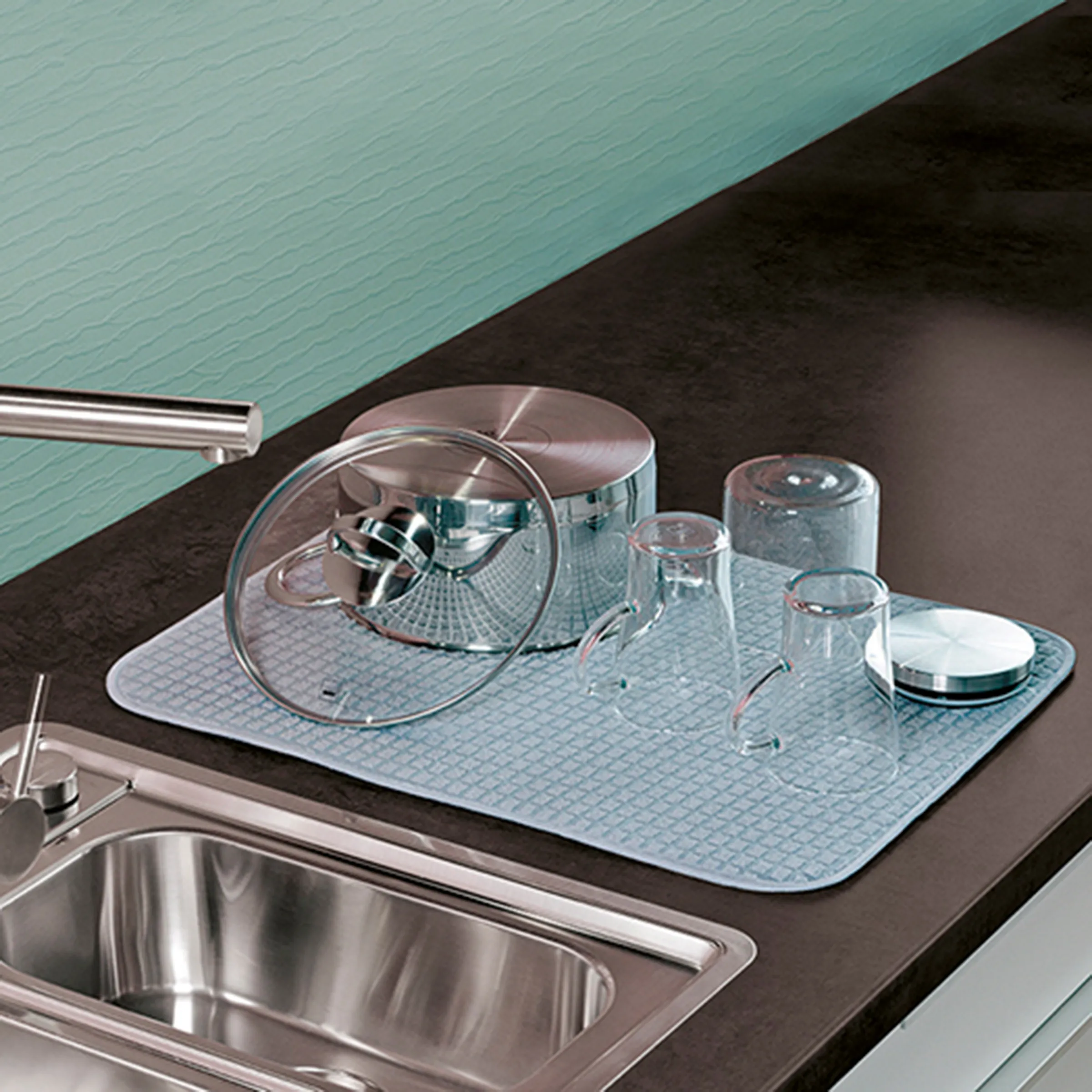 Küchen-Abtropfmatte mit Gläsern und Topfdeckel neben Spüle mit modernem Wasserhahn