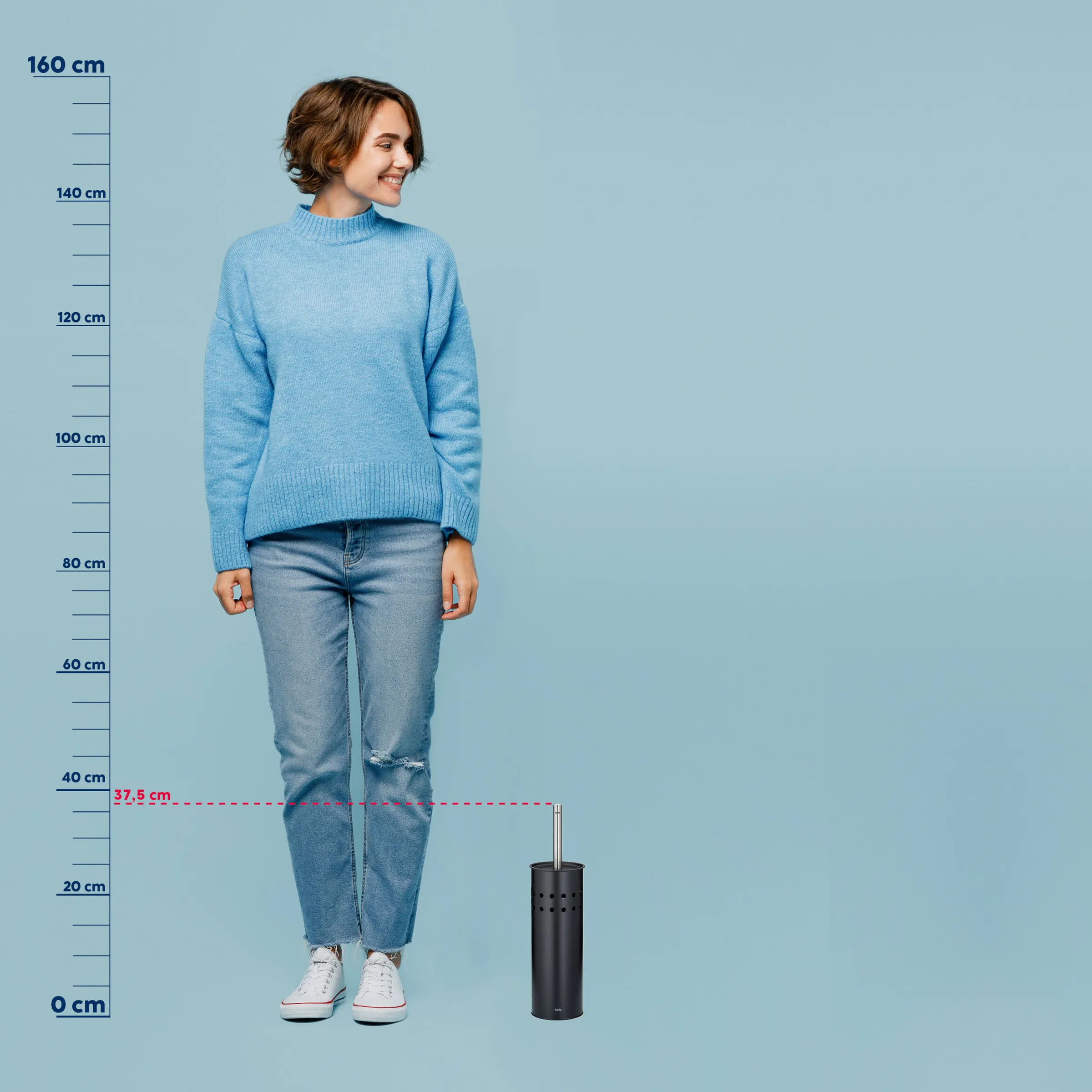 Frau in blauem Strickpullover und Jeans steht neben schwarzem Toilettenbürsten-Behälter, Größenvergleich 37,5 cm