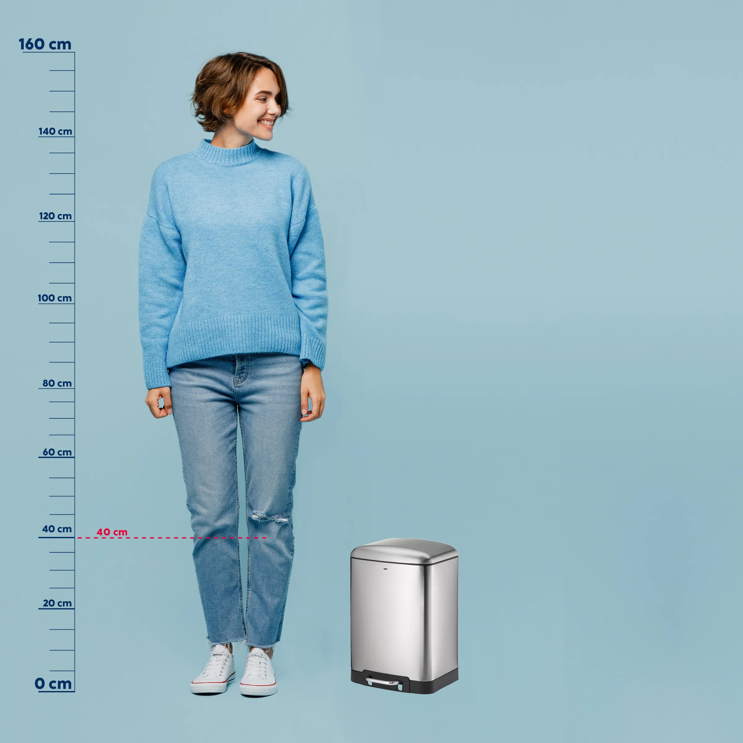 Edelstahl Mülleimer Größenvergleich - automatischer Sensor Abfalleimer Frau in blauem Pullover und Jeans steht neben einem silbernen Edelstahl-Mülleimer als Größenvergleich.