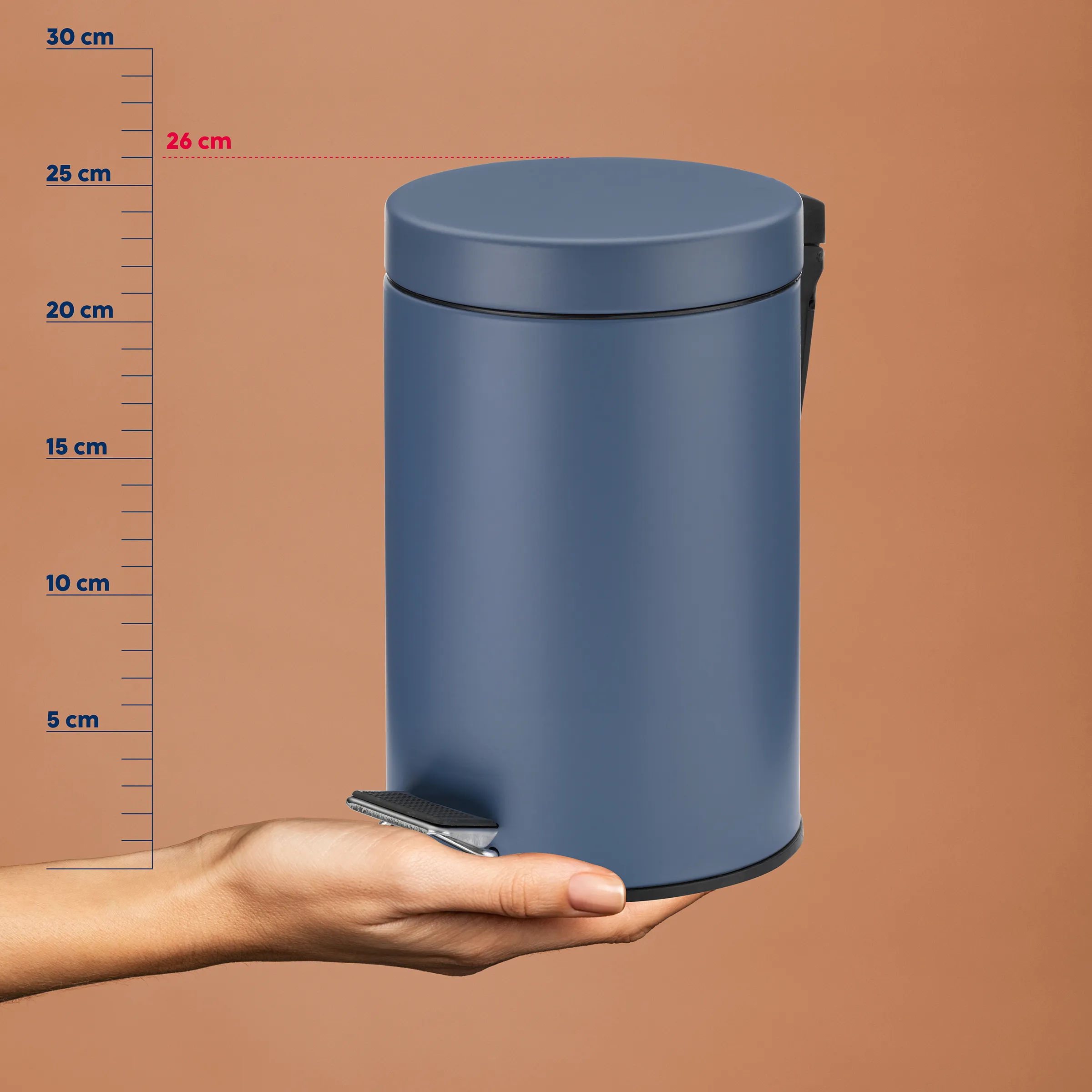Treteimer Abfallbehälter 26 cm - Edelstahl Mülleimer Blauer Tritt-Abfallbehälter mit Fußpedal, 26 cm Durchmesser, etwa 25 cm Höhe, in einer Hand gehalten vor Messskala.