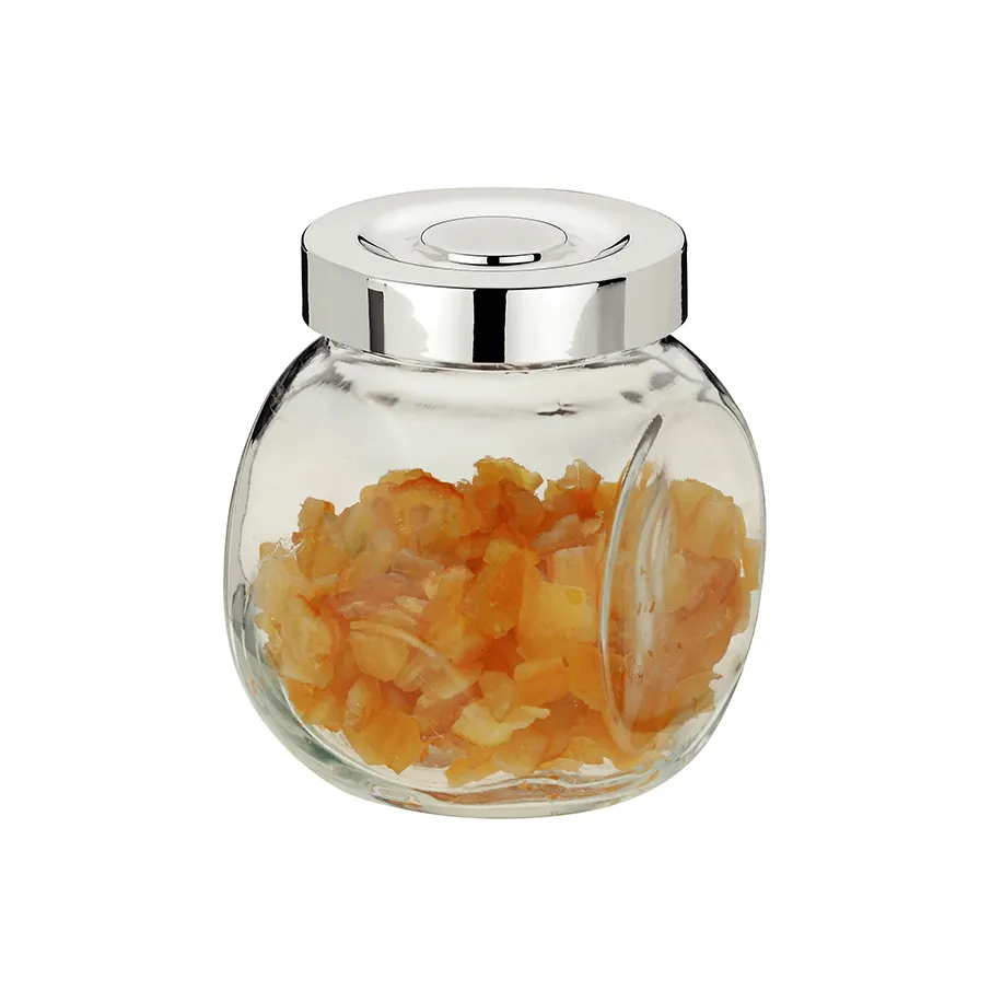 Glasdose mit Chromdeckel gefüllt mit getrockneten Karottenflocken auf weißem Hintergrund