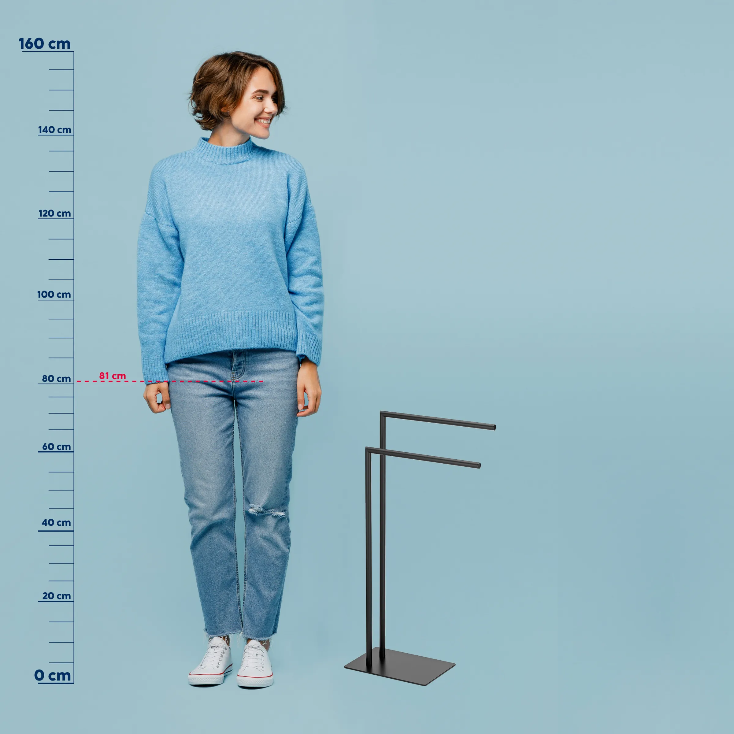 Größenvergleich Strickpullover - Produktfoto mit Messskala Junge Frau in hellblauem Strickpullover und Jeans mit Größenangaben von 0-160 cm auf blauem Hintergrund