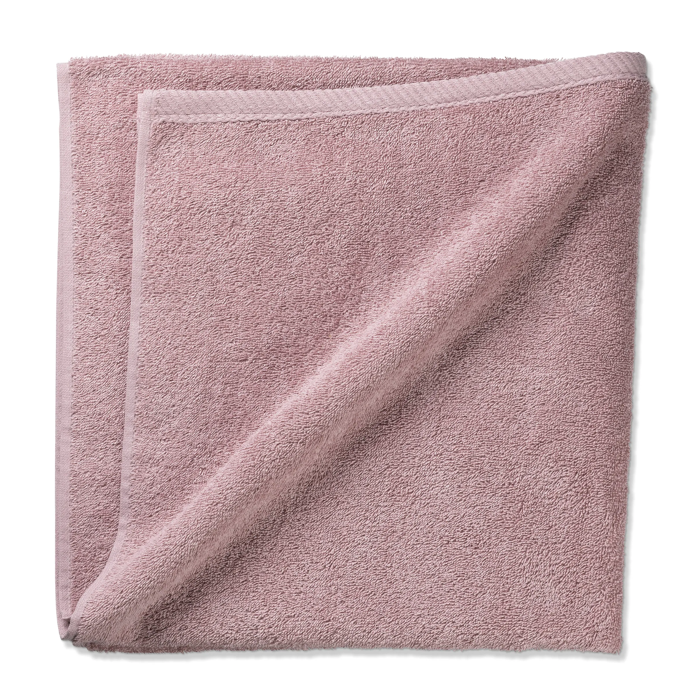Flauschiges rosa Handtuch aus hochwertiger Baumwolle Gefaltetes rosa Handtuch aus weichem Frottee-Stoff mit flauschiger Textur