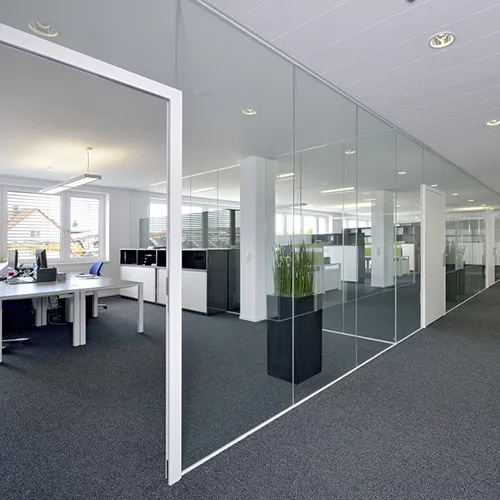 Moderne Büroeinrichtung mit Glasteilwänden und offenes Büro Design Modernes Bürogebäude mit Glaskabinen, weißem Rahmen und dunklem Boden. Innenbereich mit Arbeitsplätzen und Grünpflanzen.