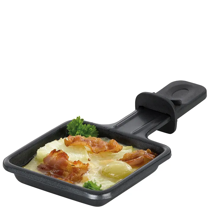 Schwarze Raclette-Pfanne mit Griff, gefüllt mit geschmolzenem Käse, Speck und Kartoffeln, garniert mit Petersilie