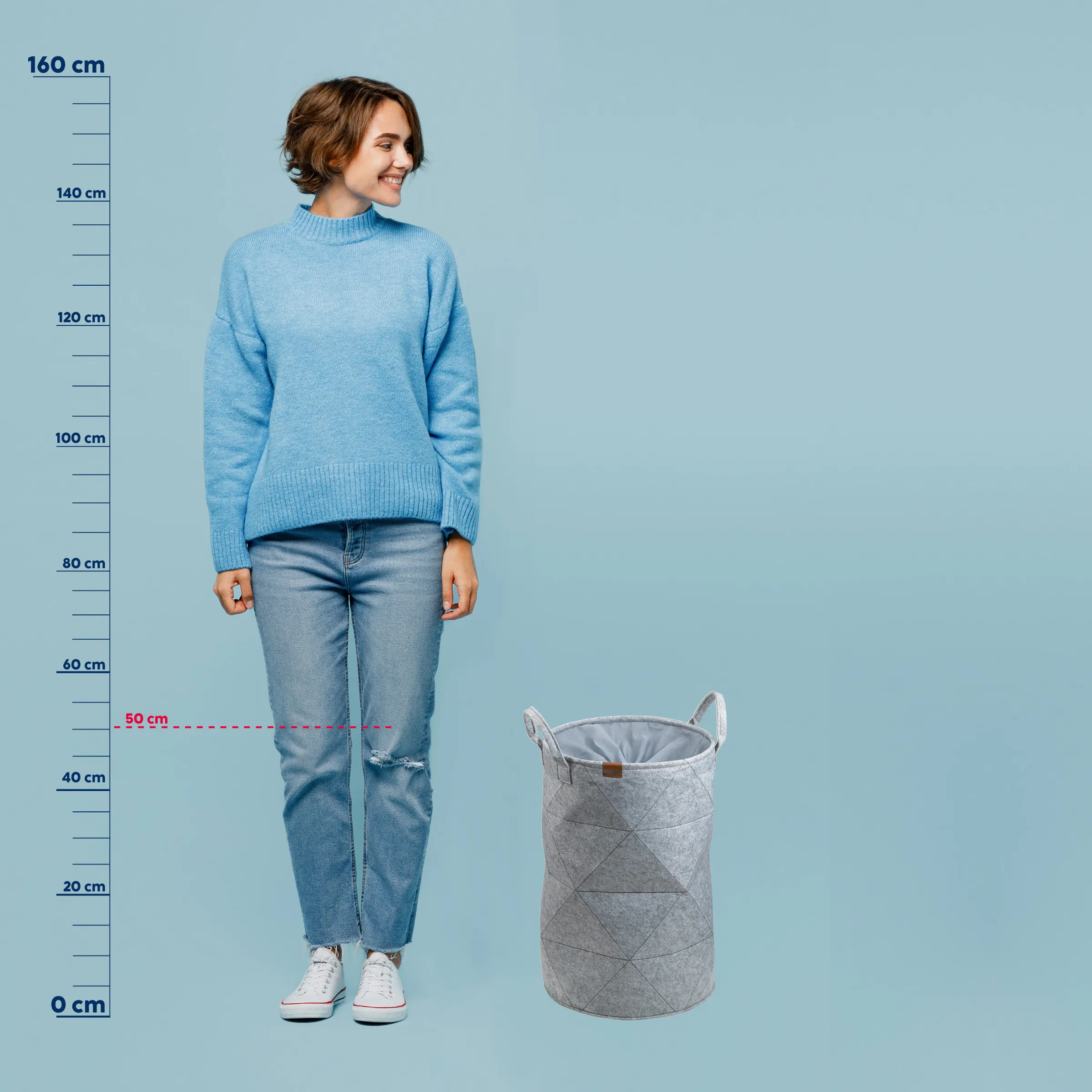 Wäschekorb Größe - Aufbewahrungskorb Vergleich Frau in blauem Pullover neben grauem Wäschekorb zur Größendarstellung, Höhenvergleich mit Messskala