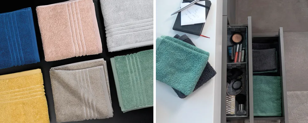 Handtücher Aufbewahrung - Farbige Badtücher Set Bunte Handtücher in verschiedenen Farben und Größen in Aufbewahrungsboxen und auf schwarzem Hintergrund arrangiert