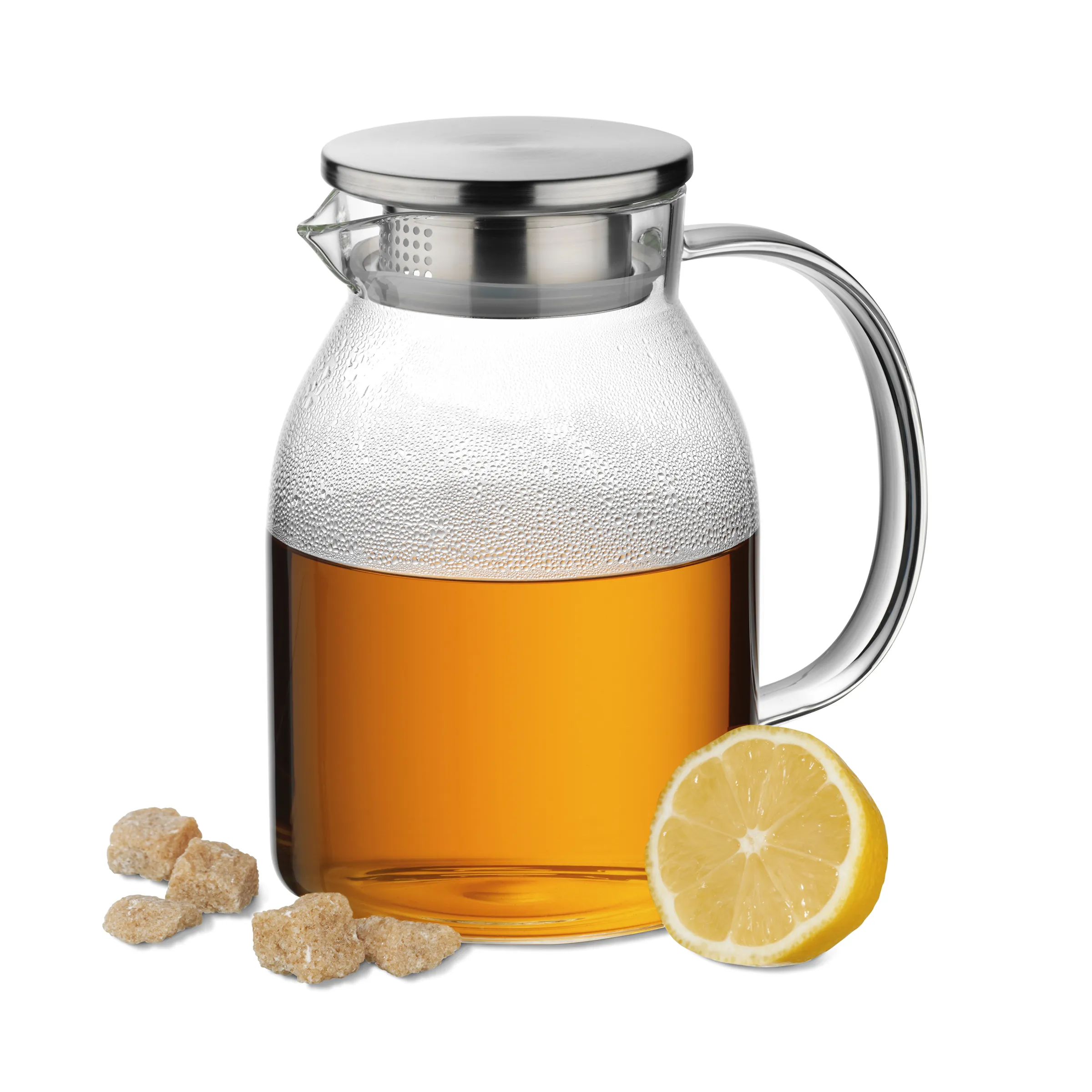 Ingwer-Zitrone Tee - Glaskaraffe mit Teefilter Glaskanne mit Teefilter gefüllt mit gelblichem Tee, daneben Ingwer und Zitronenscheibe