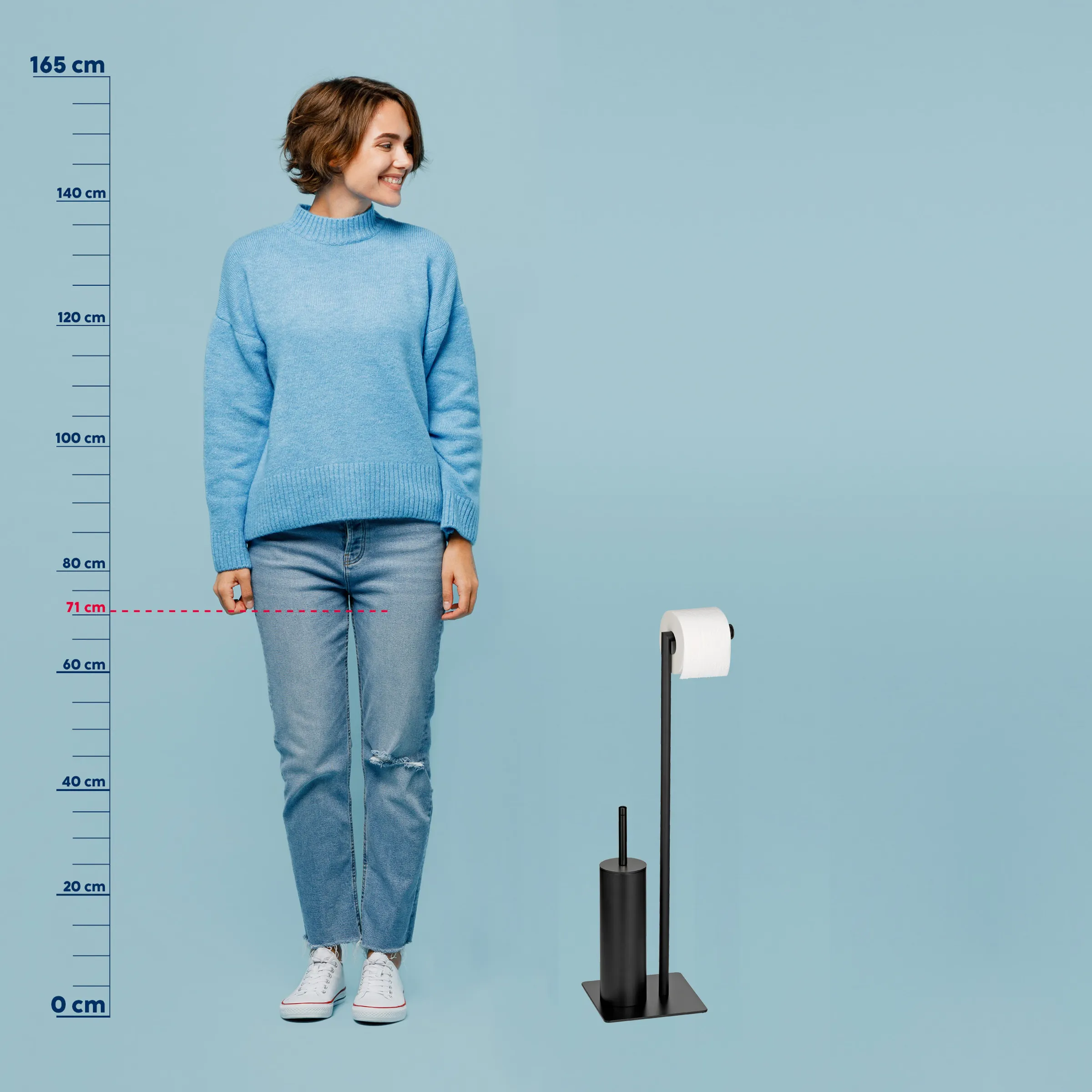 Toilettenpapierhalter stehend - Design Badezimmeraccessoire Frau in blauem Pullover und Jeans neben schwarzem Toilettenpapierhalter mit Maßstab, 71 cm Höhe markiert