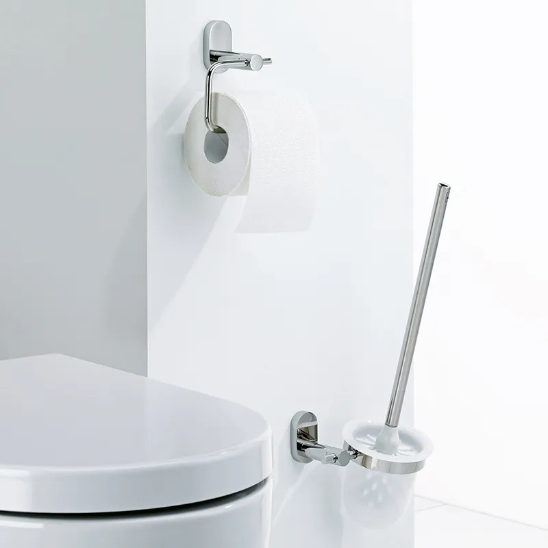 Modernes Badezimmer mit weißer Toilette, Toilettenpapierhalter mit Rollen und Toilettenbürste mit chromgepoliertem Griff