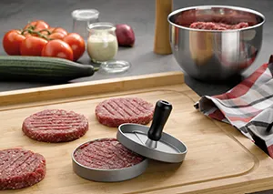 Burgerpresse für perfekte Hamburger-Patties - Küchenhelfer für Hackfleisch Burgerpresse formt Hackfleisch-Patties auf Holzbrett, daneben Schüssel mit Hackfleisch und frische Zutaten