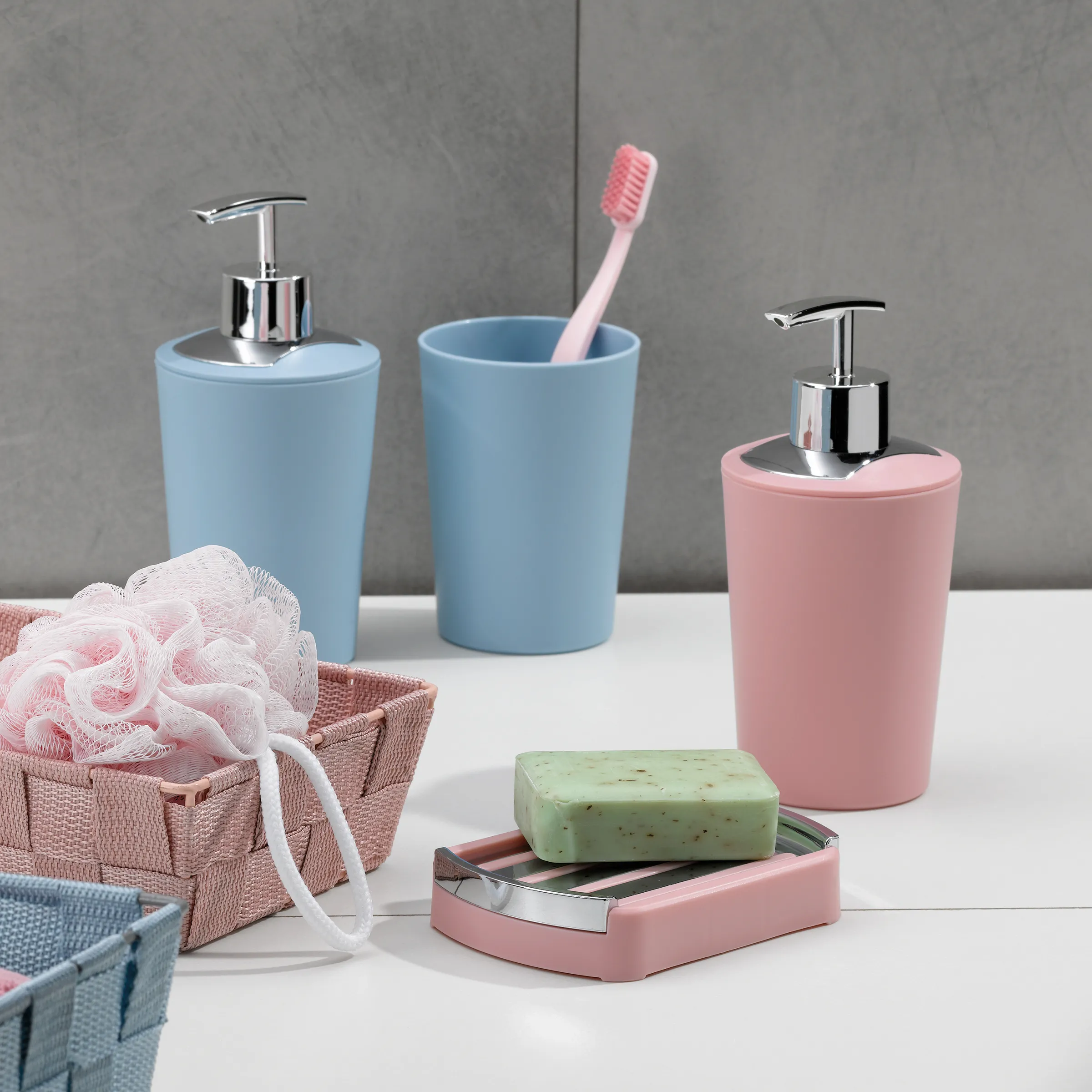 Badezimmer-Accessoires Set mit blauen und rosa Behältern, Seifenspender, Zahnbürstenhalter und Seifenschale mit grüner Seife