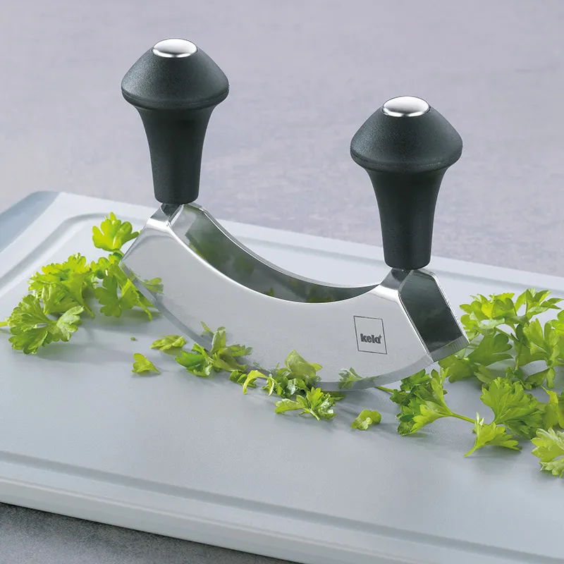 Wiegemesser mit zwei Griffen zum Kräuter hacken - Küchenhelfer Doppelter Wiegemesser mit ergonomischen Griffen auf Schneidebrett mit frischer Petersilie