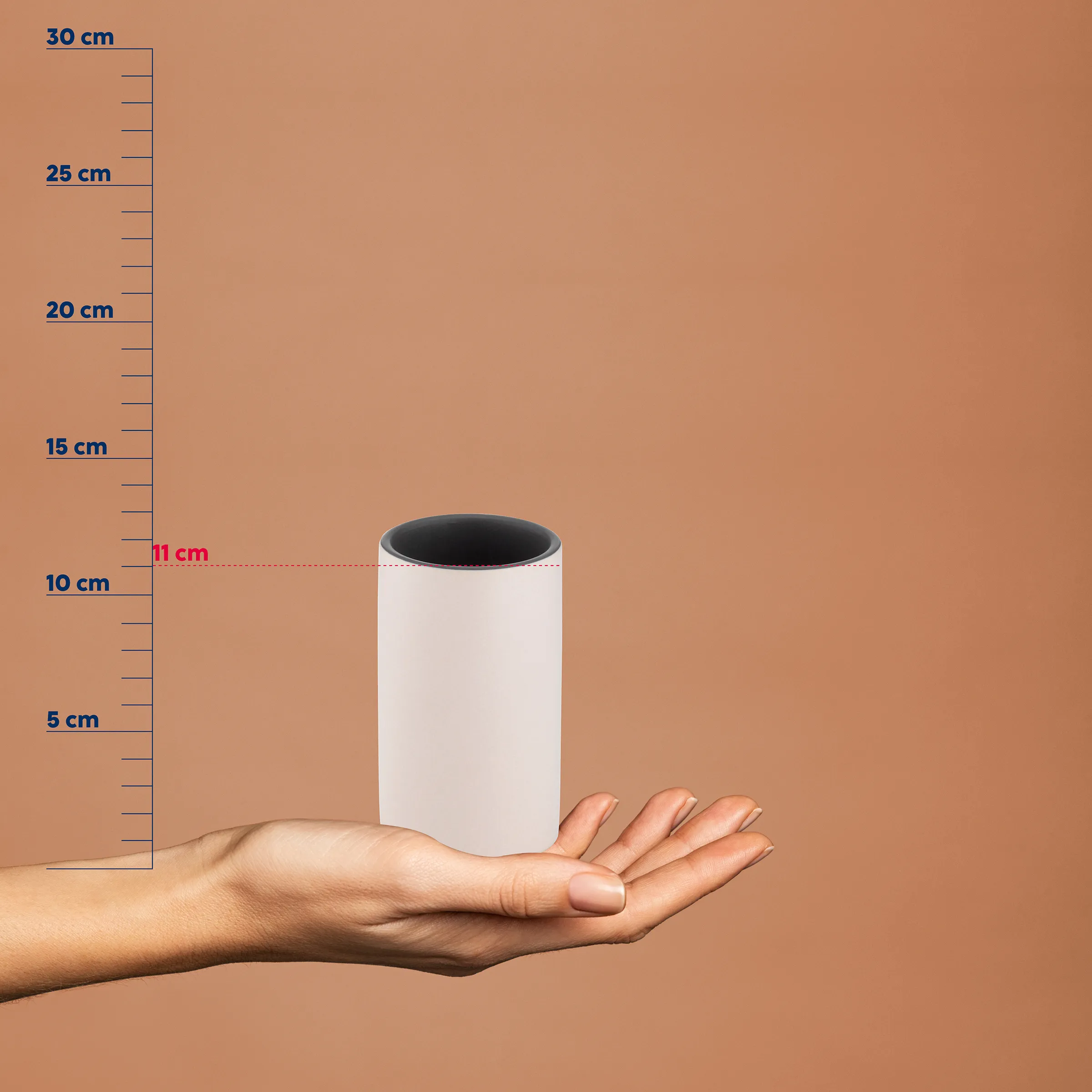 Weiße Zylinder Dose Größenvergleich Produktfoto Weiße Zylinderform mit schwarzer Öffnung auf einer Hand, daneben eine Messskala von 0-30 cm, Höhe etwa 11 cm