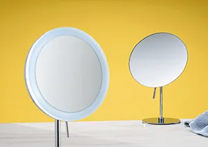 Zwei moderne LED-Kosmetikspiegel mit Beleuchtung auf gelbem Hintergrund, großer ovaler Standspiegel und kleinerer runder Tischspiegel