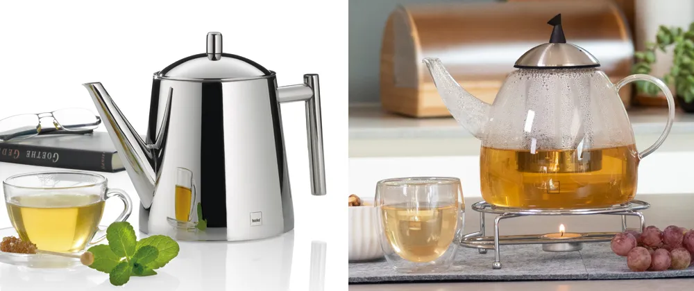 Teekanne Edelstahl und Glas - Premium Tee-Sets Zwei moderne Teekanne-Sets: Linke silberne Edelstahl-Kanne mit Teetasse und Minzblättern, rechte Glaskanne mit Tee auf Wärmestöcken mit Trauben.