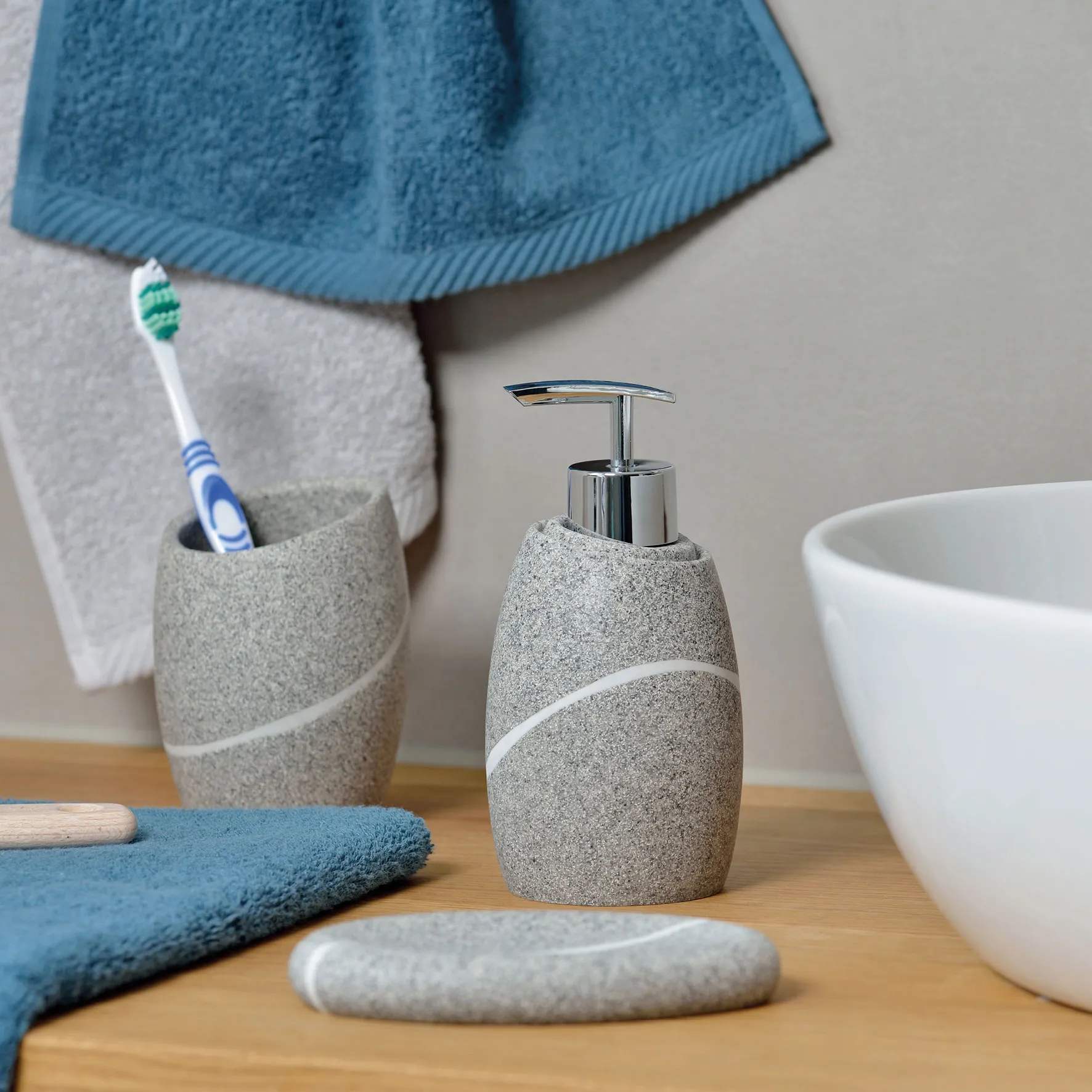 Graues Badezimmer-Seifenspender-Set mit Zahnbürstenhalter, weißem Handtuch und blauen Accessoires