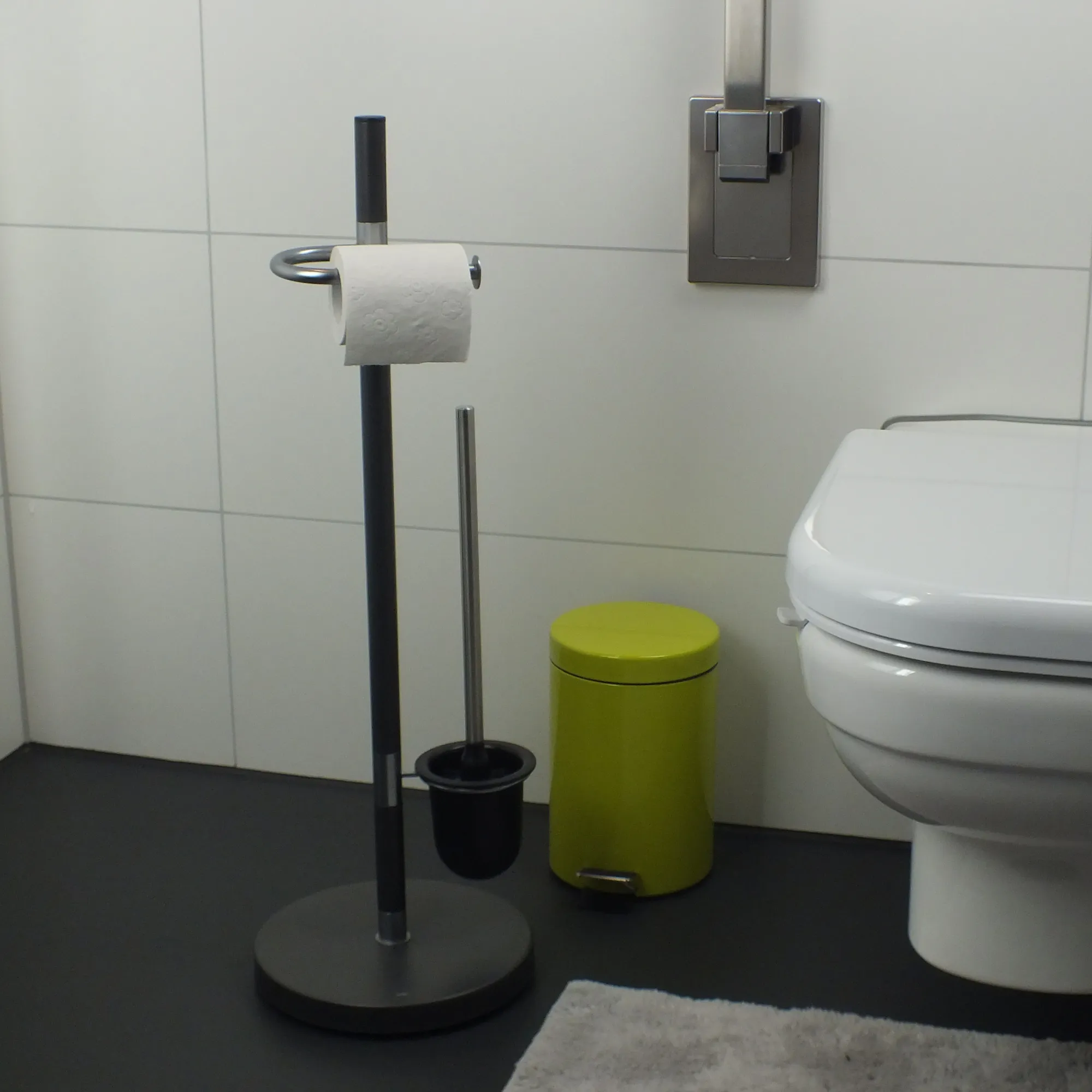 Badezimmer Accessoires Set - Toilettenpapierhalter und Bürste Modernes Badezimmer mit schwarzem Toilettenpapierhalter, schwarzer Toilettenbürste, grünem Mülleimer und weißer Toilette