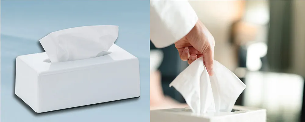 Kosmetiktücher Box weiß - Papiertaschentücher Spender für Haushalt und Büro Weiße Kosmetiktücherbox mit herausgezogenen Papiertüchern, Hand entnimmt ein Taschentuch