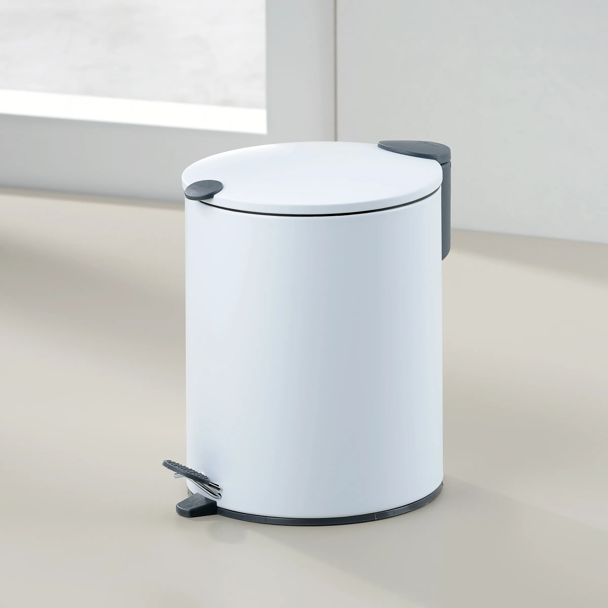 Tritt-Mülleimer weiß - Design Abfalleimer für Büro Weißer Tritt-Mülleimer mit schwarzen Griffen und Deckel auf hellem Boden in moderner Büroumgebung