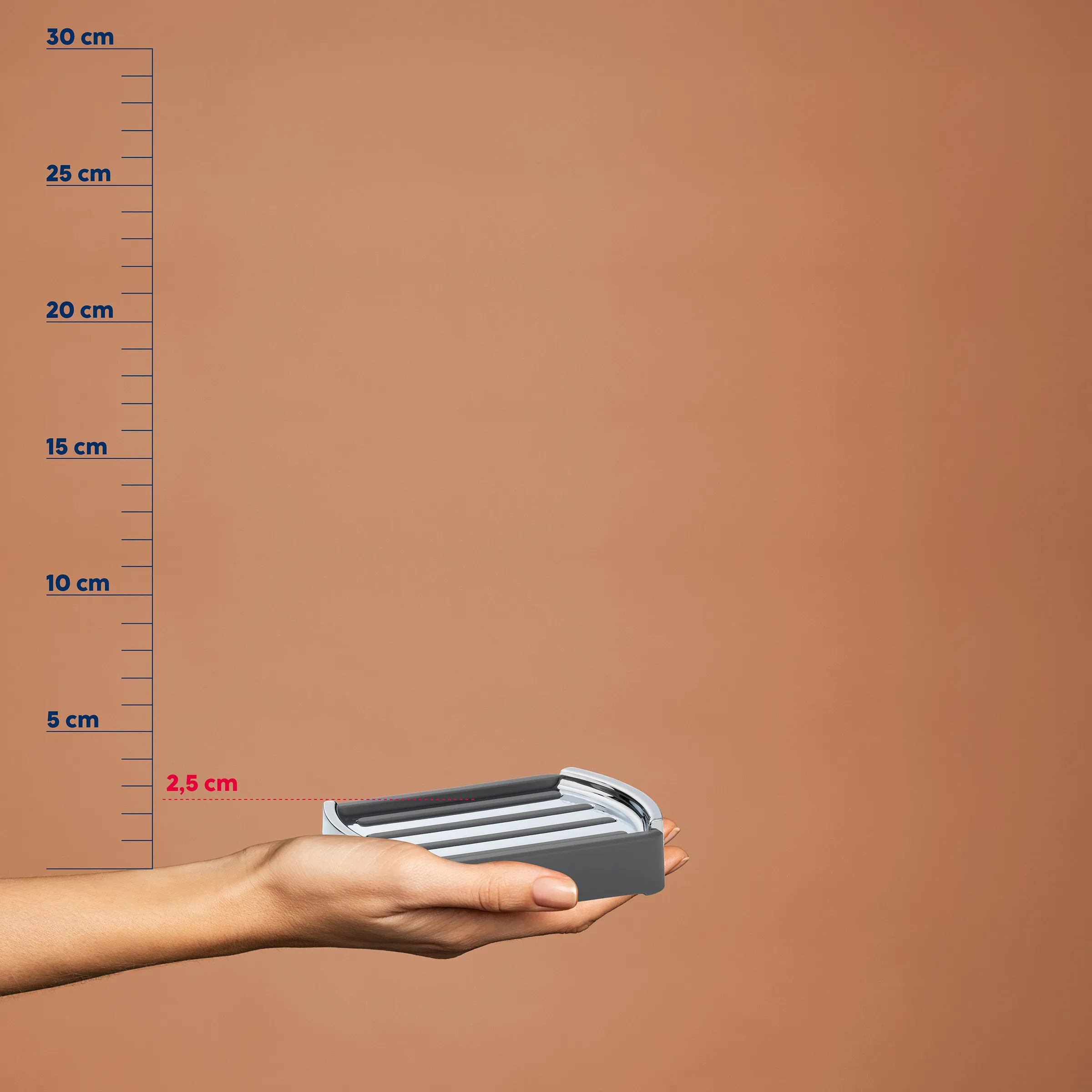 Hand hält kompakte graue Rasierklingen-Kartusche mit mehreren Klingen vor Messskala, Höhe 2,5 cm
