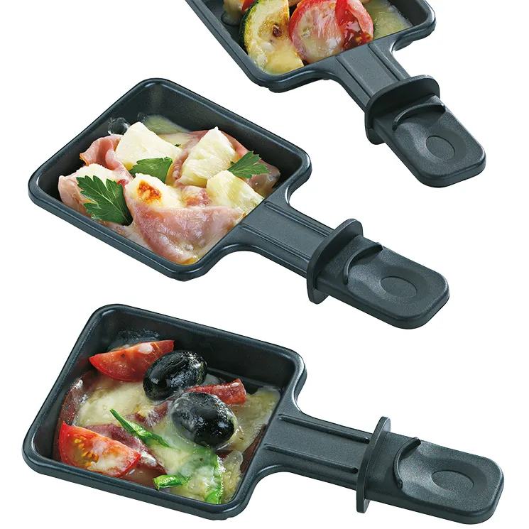 Raclette Pfännchen Set - Käse Fondue Zubehör Drei schwarze Raclette-Pfännchen mit Gemüse, Fleisch und Käse gefüllt auf weißem Hintergrund