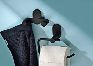 Zwei schwarze Handtuchhalter mit modernem Design an türkiser Wand, einer hält ein dunkles, einer ein helles Handtuch.