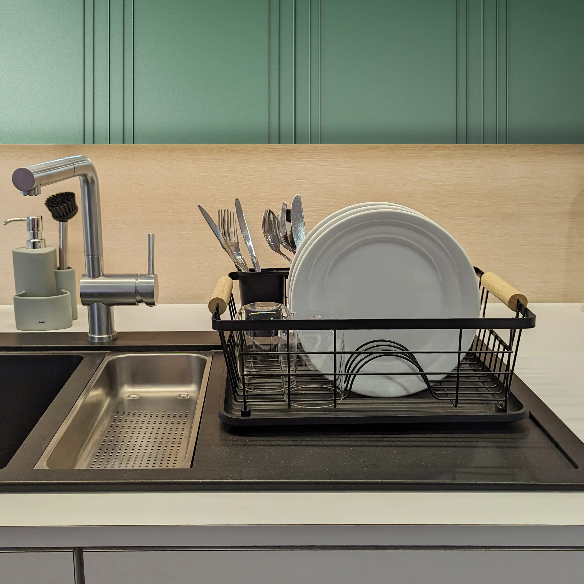 Abtropfgestell Küche mit Besteckhalter - Modernes Geschirr Organizer Set Schwarzes Abtropfgestell mit Geschirr und Besteck neben Edelstahl-Küchenarmatur auf dunkler Arbeitsplatte
