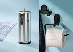 Papierhalter und Toilettenpapierständer Set Edelstahl-Papierhalter und schwarzer Wandhalter mit Toilettenpapier-Rollen auf blauem Untergrund.