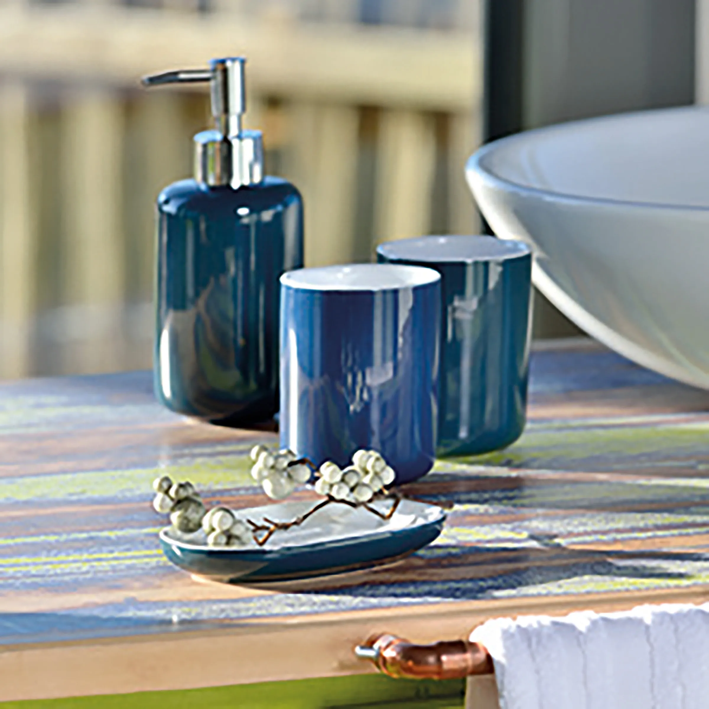 Blaues Badezimmer Accessoires Set - Seifenspender & Halter Elegantes blaues Badezimmer-Accessoire-Set mit Seifenspender, Zahnbürstenhaltern und Seifenschale auf gestreiftem Teppich