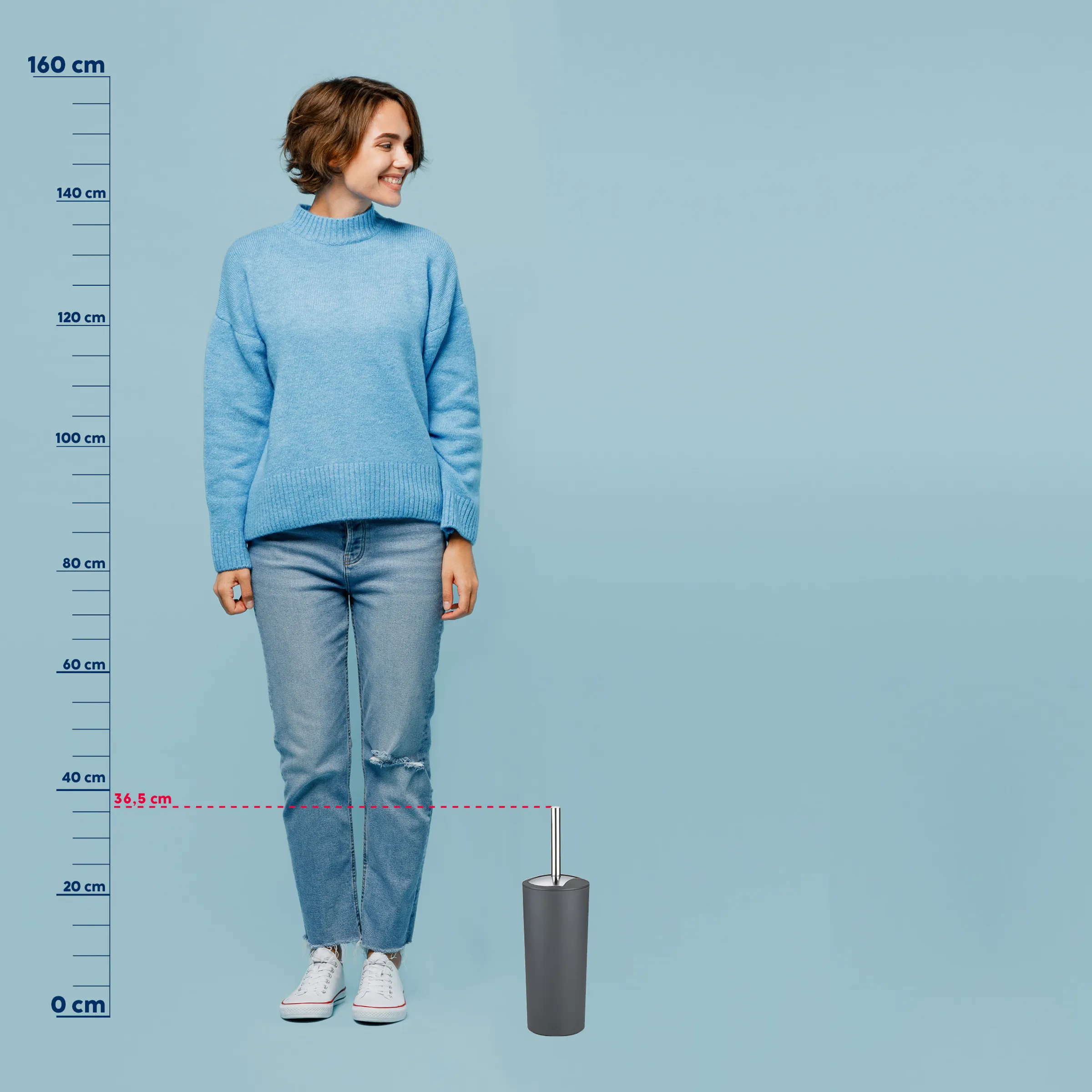 Frau mit braunem Haar trägt hellblauen Stehkragen-Pullover und Jeans. Größenvergleich mit Messstab zeigt 36,5 cm Breite.