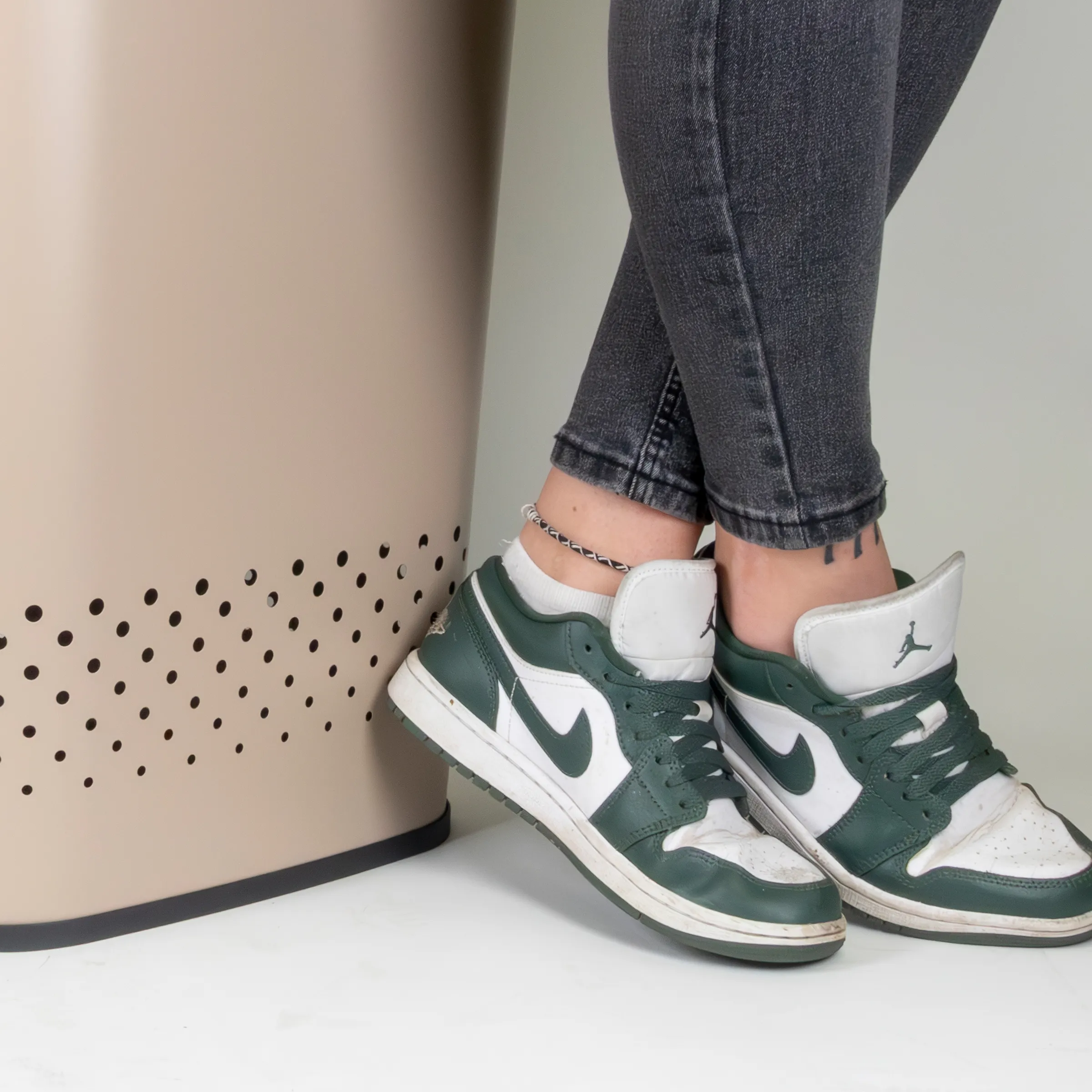 Person trägt grün-weiße Sneakers mit grauen Jeans, stylisches Outfit mit Anklet
