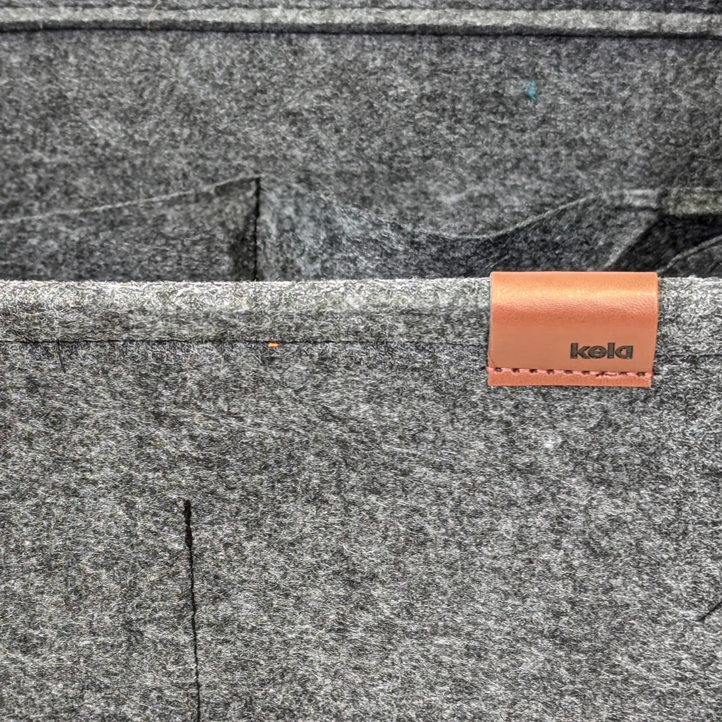 Koala Lederlabel auf grauer Wollstoffoberfläche mit Steppnähten befestigt