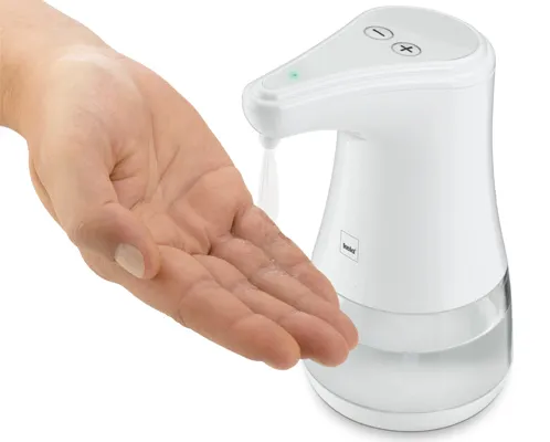 Hand vor weißem automatischem Seifenspender mit Sensor und Tropfauffangbehälter