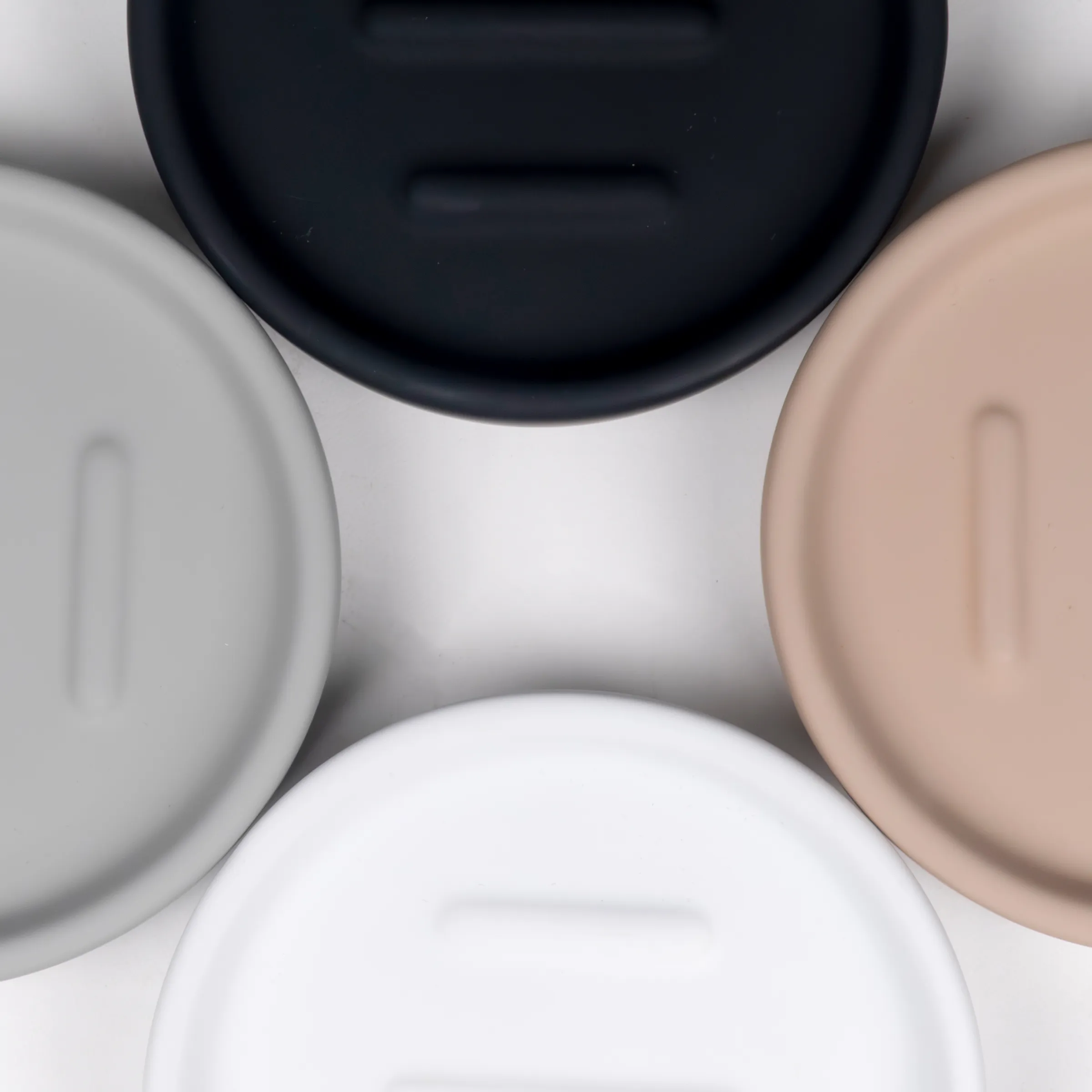 Behälter Set mit Deckel - Aufbewahrungsbehälter in verschiedenen Farben Vier Behälter mit Deckel in verschiedenen Farben: Schwarz, Weiß, Grau und Beige, von oben fotografiert