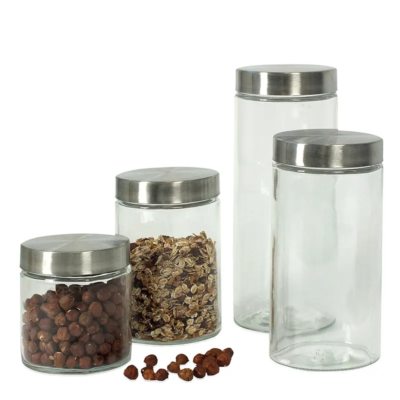 Vier Glasdosen mit Edelstahldeckel in verschiedenen Größen, zwei gefüllt mit Nüssen und Müsli