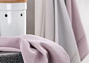 Rosa Strickdecke auf Bett – gemütliche Wohntextilien und Schlafzimmer Dekoration Rosa Strickdecke auf Bett mit weißem Schrank und grauen Vorhängen im Hintergrund