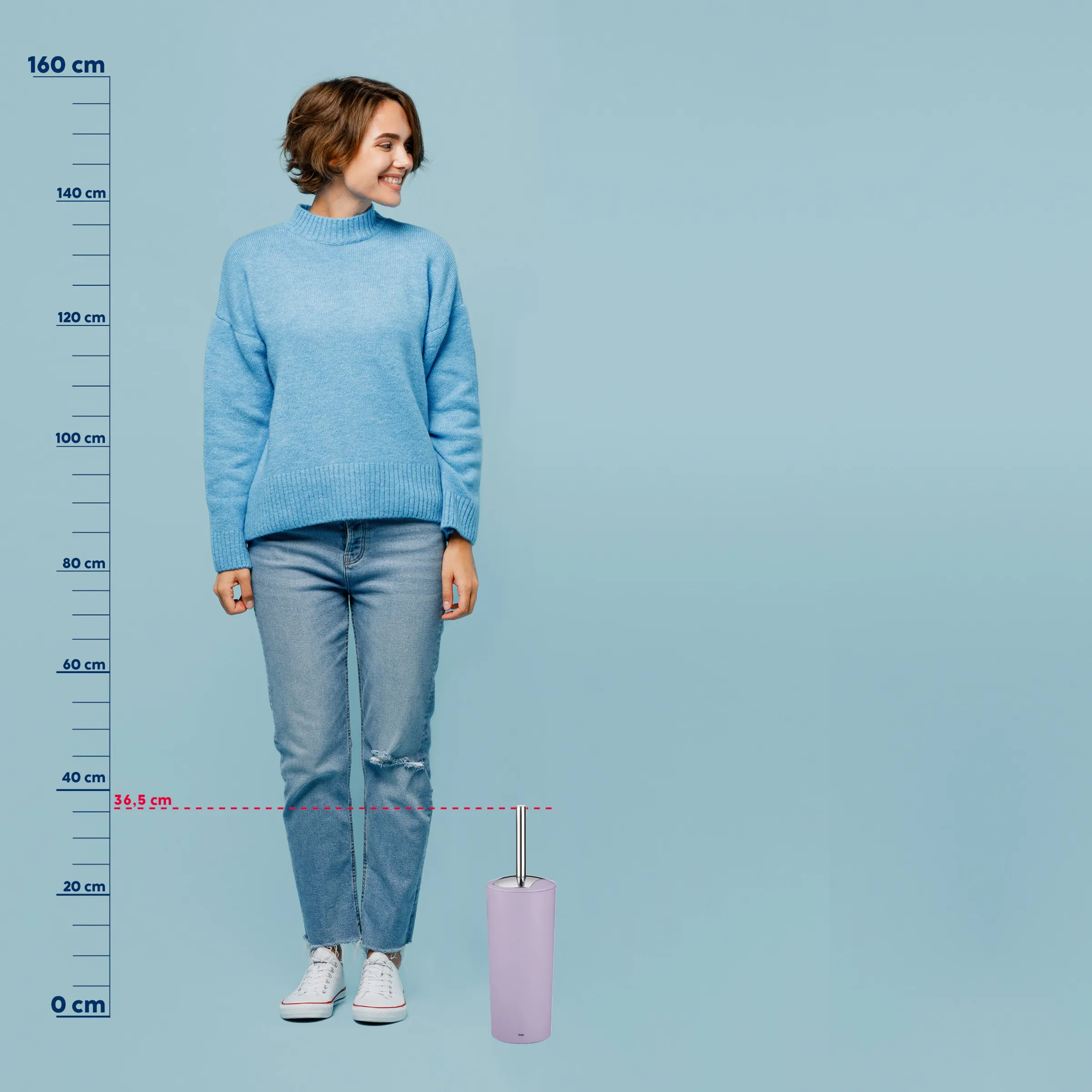 Frau in blauem Strickpullover und Jeans mit Größenvergleich zu einem rosa Toilettenbürsten-Set, Körpergröße ca. 155 cm