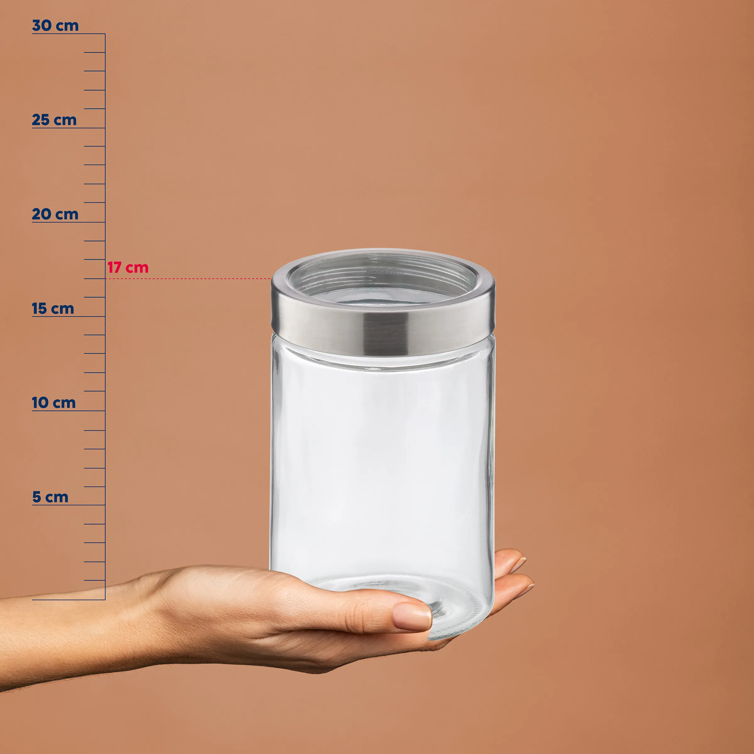 Transparentes Glasgefäß mit Metalldeckel in einer Hand, neben einer Messskala mit Zentimeterangaben von 5 bis 30 cm.