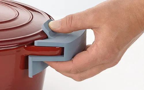 Topfdeckel mit Clip-Verschluss - praktischer Griff zum einfachen Öffnen Hand öffnet roten Topfdeckel mit blauem Griff-Clip-Verschluss